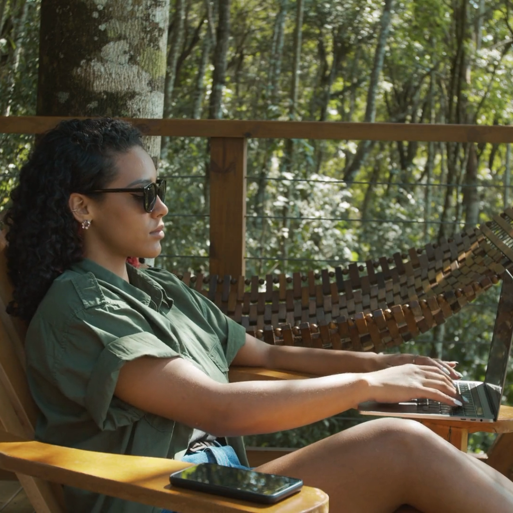 Young woman working on her laptop while enjoying the beautiful Yucatan jungle in Mexico's beautiful Riviera Maya.