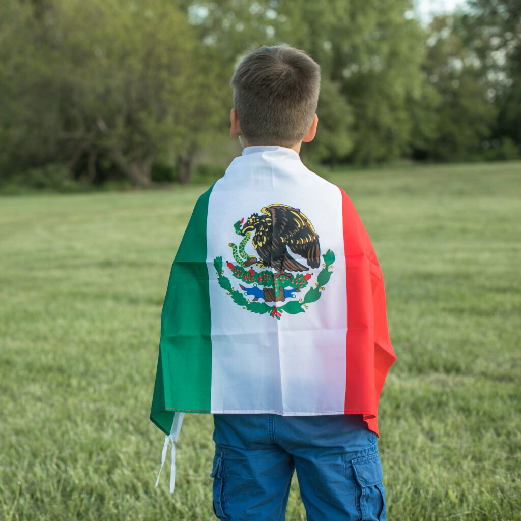 Young boy holding Mexican flag celebrating September 16, Mexico's Independence Day